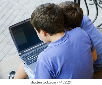 Two young boys learning together on a computer, representing digital education, teamwork and childhood technology.