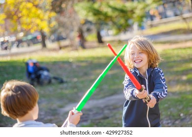 Two young brothers, play fighting with laser swords