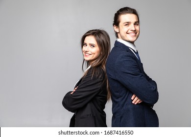 Two Young Business People Standing Back To Back With Hands Crossed On Grey Background