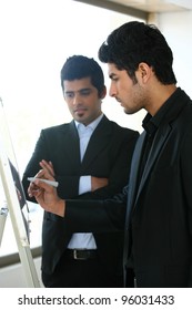 Two Young Businessmen Discussing Business Strategy In A Meeting, Indian Business Man With Latin American Colleague, Two Serious Businessmen,