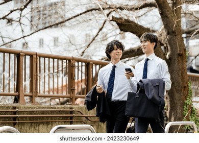 Two young businessmen men who walk side by side with a smartphone with a smartphone with a smartphone with a smartphone