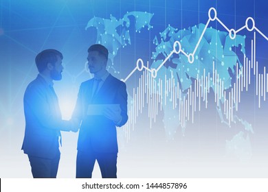Two young businessmen shaking hands over blue background with world map and graphs. Concept of international partnership. Toned image - Shutterstock ID 1444857896