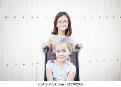 Two young children, one in a wheelchair, space for text - Powered by Shutterstock