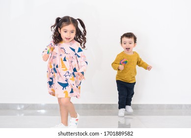 Two Young Children Running Towards Camera In Home. Soft Focus To Show Movement.