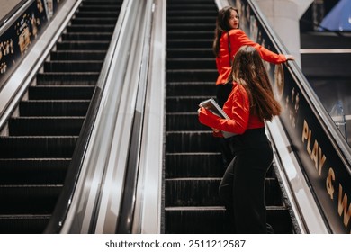 Two young corporate business partners in red blazers riding an escalator in an office building. Focus on professional attire and teamwork. - Powered by Shutterstock