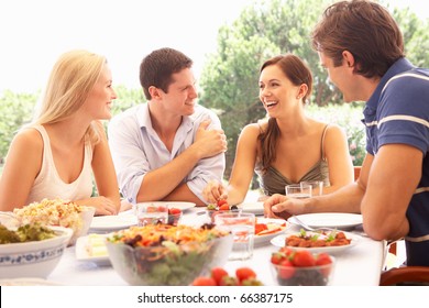 Two Young Couples Eating Outdoors