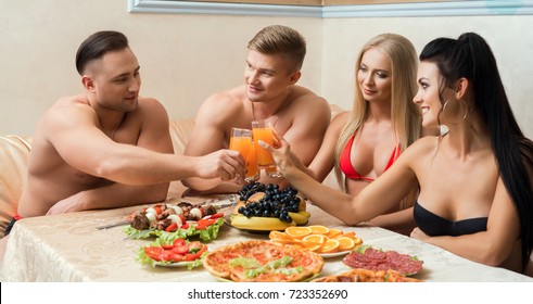 Two young couples at table with fruit and shashlik