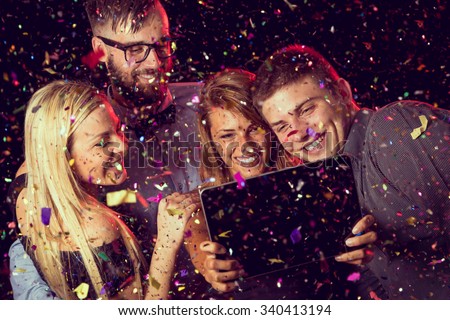 Two young couples taking a selfie at midnight on a New Year's Eve party