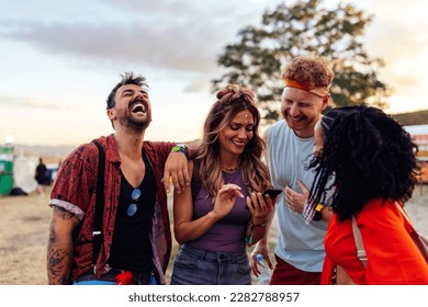 Two young couples are together at a summer music festival, having fun during the day party.
