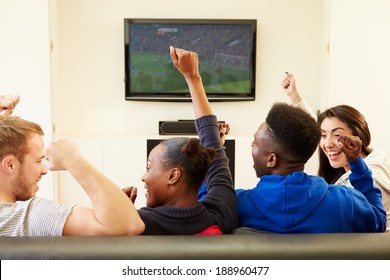 Two Young Couples Watching Television At Home Together