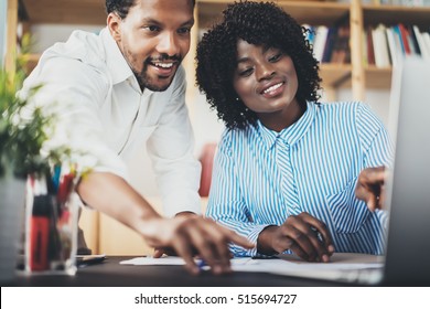 Two young coworkers working together in a modern office.Black business partners discussing new startup project.Horizontal,blurred