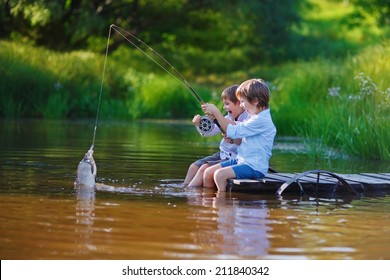 Two young cute boys fishing on a lake in a sunny summer day. Kids are playing. Friendship.