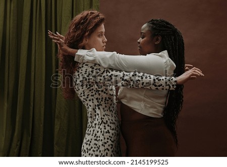 Two young diverse girlfriends bonding