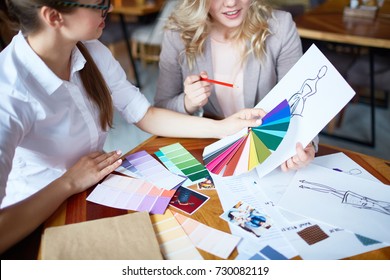 Two young fashion designers choosing trendy colors for new collection of clothes - Shutterstock ID 730082119