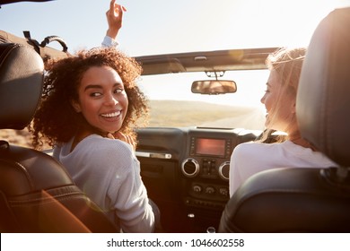 Two Young Female Friends Driving A Car In The Sun, Side View