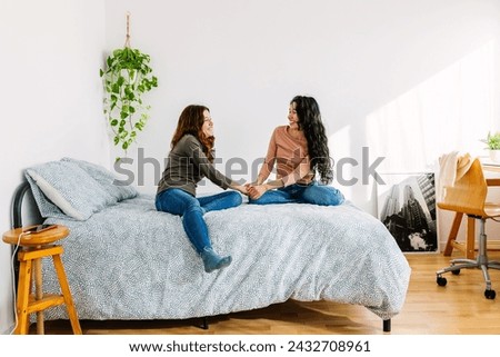 Two young female friends enjoying time together relaxing on bedroom. Millennial student girls gathering at home