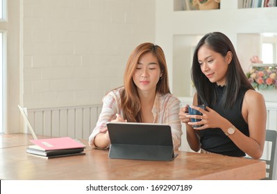 Two Young Female Students With Coffee Are Using A Laptop To Study Online At Home In The Summer Semester,Work At Home,Work From Home.