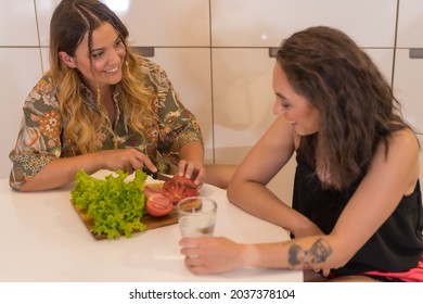 Two Young Friends Making A Salad In The Kitchen