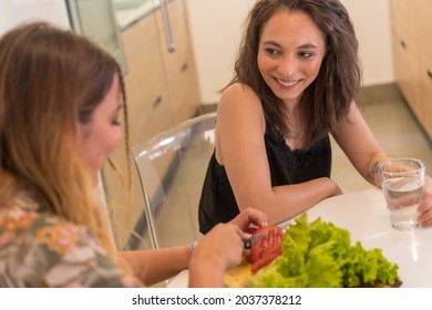 Two Young Friends Making A Salad In The Kitchen