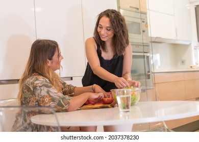 Two Young Friends Making A Salad In The Kitchen