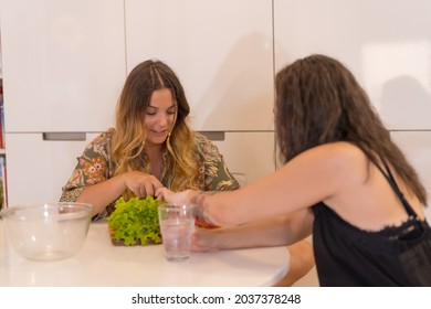 Two Young Friends Making A Salad In The Kitchen