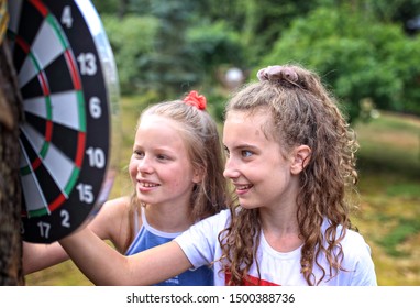 Two Young Friends Play Darts Outdoors