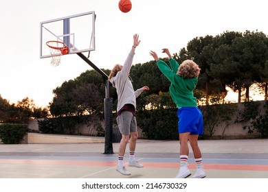 Two Young Friends Playing Basketball On A City Court, Concept Of Urban Sport In The Street, Copy Space For Text