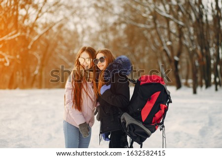 two young friends are walking in the winter snow-covered forest