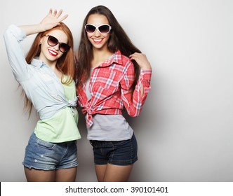 Two young girl friends standing together and having fun. 