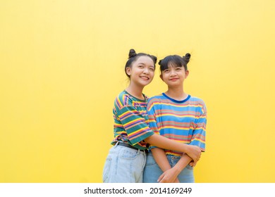 Two Young Girl On Yellow Background.Asain Girl.