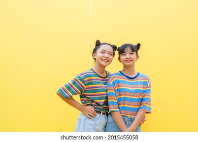 Two Young Girl On Yellow Background.Asain Girl.