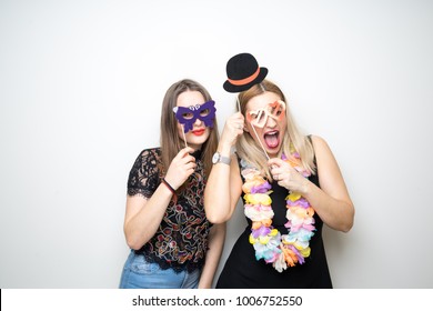 two young girls pose photo booth props happy funny white background smile models 