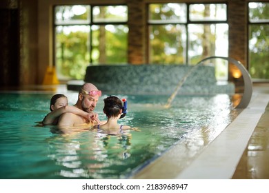 Two young girls and their father having fun in indoor pool. Child learning to swim. Kid having fun with water toys. Family fun in a pool. Activities for family with kids. - Powered by Shutterstock