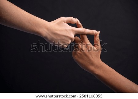 two young hands making the infinity sign on black background