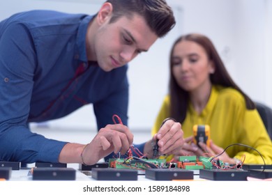 Two young handsome engineers working on electronics components.Tech tests electronic equipment in service center. Technologically Advanced Scientific Research Center.