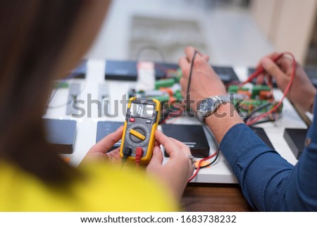 Two young handsome engineers working on electronics components.Tech tests electronic equipment in service center. Technologically Advanced Scientific Research Center.
