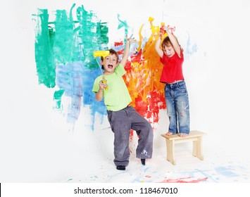 Two Young Happy Children - Boy And Girl - Painting White Wall