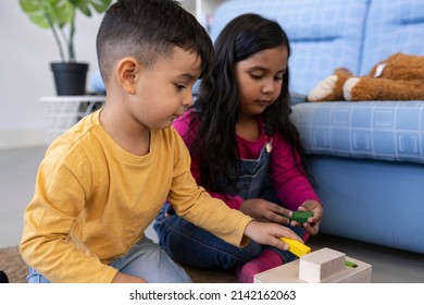 Two Young Hispanic Boy And Girl Playing At Home