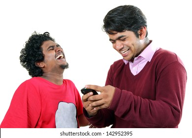 Two young  Indian students reading messages on their  mobile and  laughing out loud.