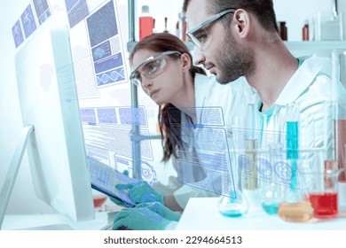 Two Young laboratory scientists look at the display and working with Futuristic Holographic Interface, showing medical Data in augmented reality from artificial intelligence AI