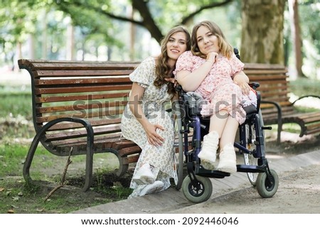 Similar – Woman carrying her mother in a wheelchair