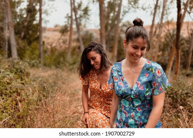 Two Young Lesbians Walking In The Woods Wearing Long Dresses