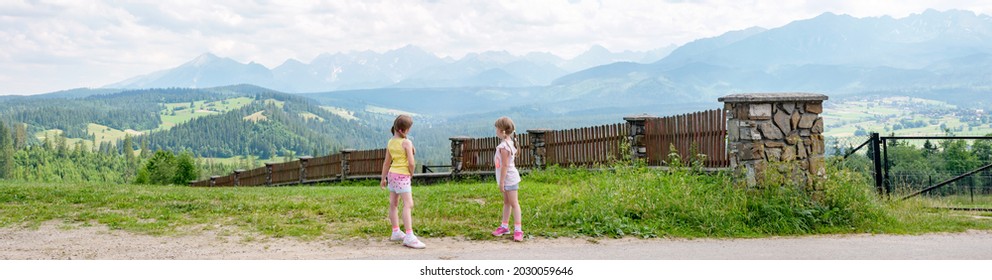 Two Young Little School Age Girls Looking At Tatra Mountains Range, Exploring, Tatras Polish Side, High Resolution HQ Panorama. Travelling, Europe Trip Journey Destinations, Holidays, Vacations