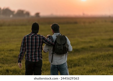 Two young males wandering through fields under the sunset sky - Powered by Shutterstock