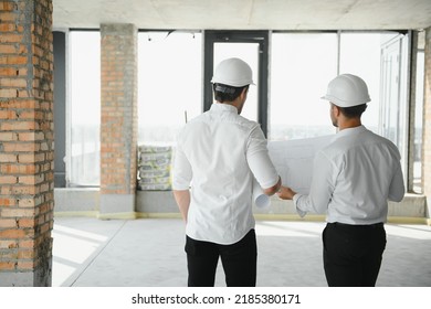 Two young man architect on a building construction site.