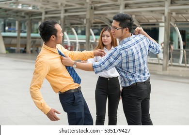 Two Young Man Fighting Over Each Other While Another Woman Attempt To Stop Them.