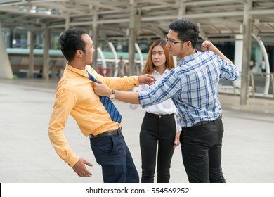 Two Young Man Fighting Over Each Other While Another Woman Attempt To Stop Them.