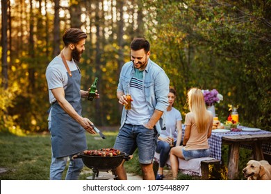 Two Young Man Making Barbecue Outdoors