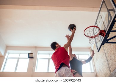 Two Young Man Playing Basketball Indoors