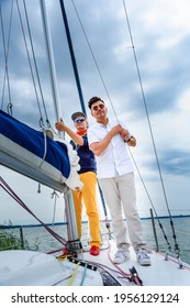 Two Young Man Standing On A Sailboat. Summer Vacations, Cruise